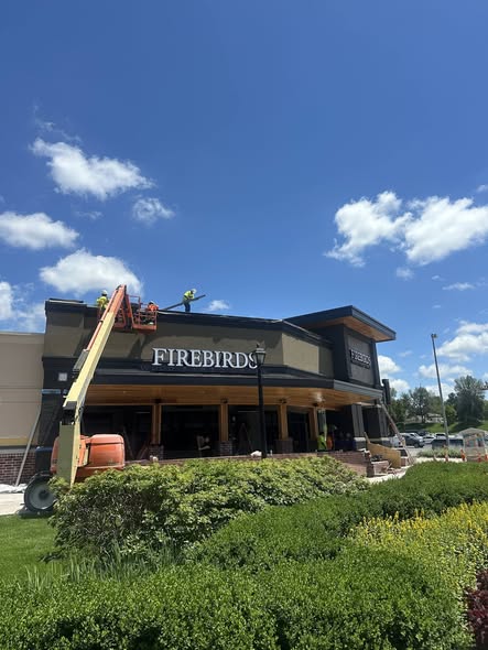 Firebirds Wood-Fired Grill exterior, crew on lift